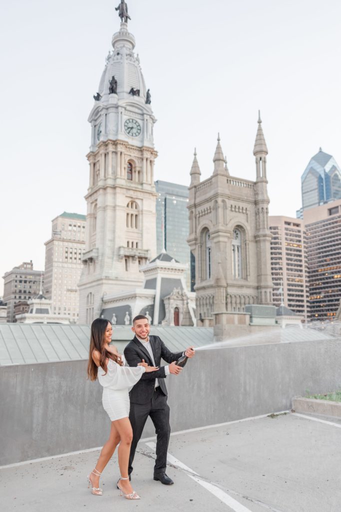 Couple popping champagne during engagement photos