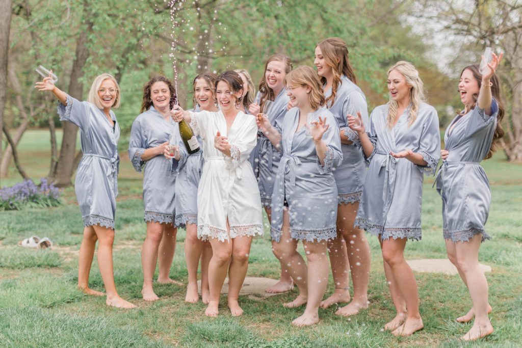 bride champagne pop with bridesmaids