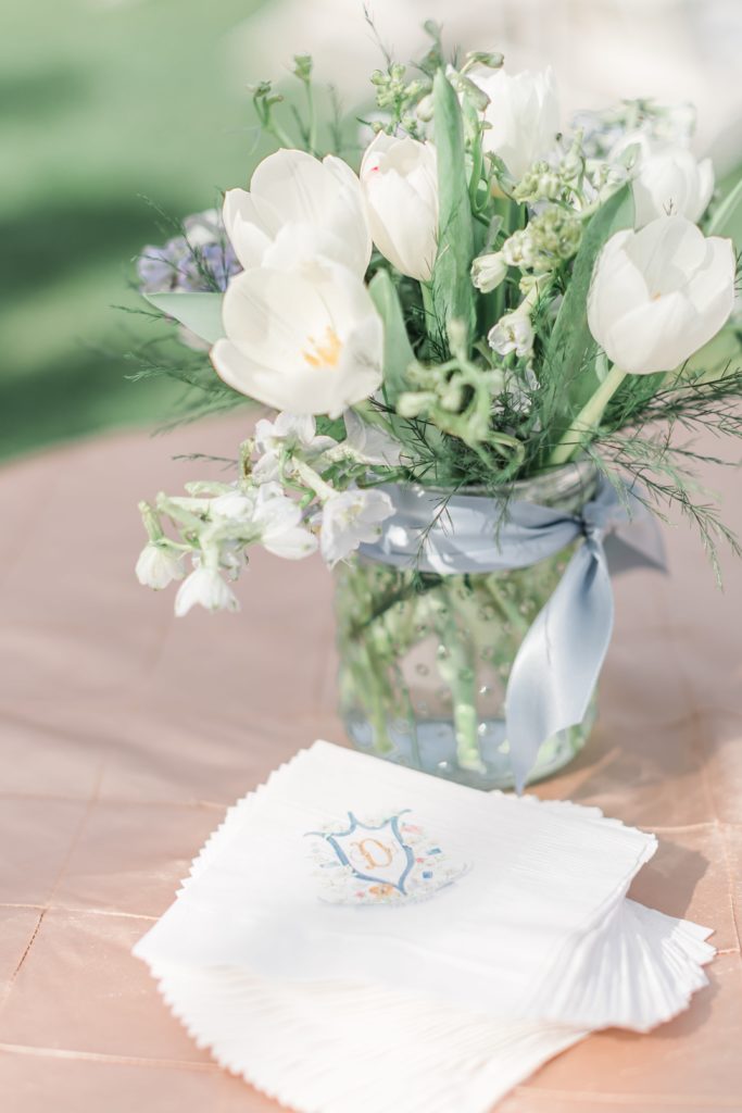 White tulip arrangement with wedding crest napkins