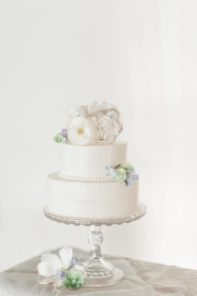 Two tiered white buttercream wedding cake with flowers