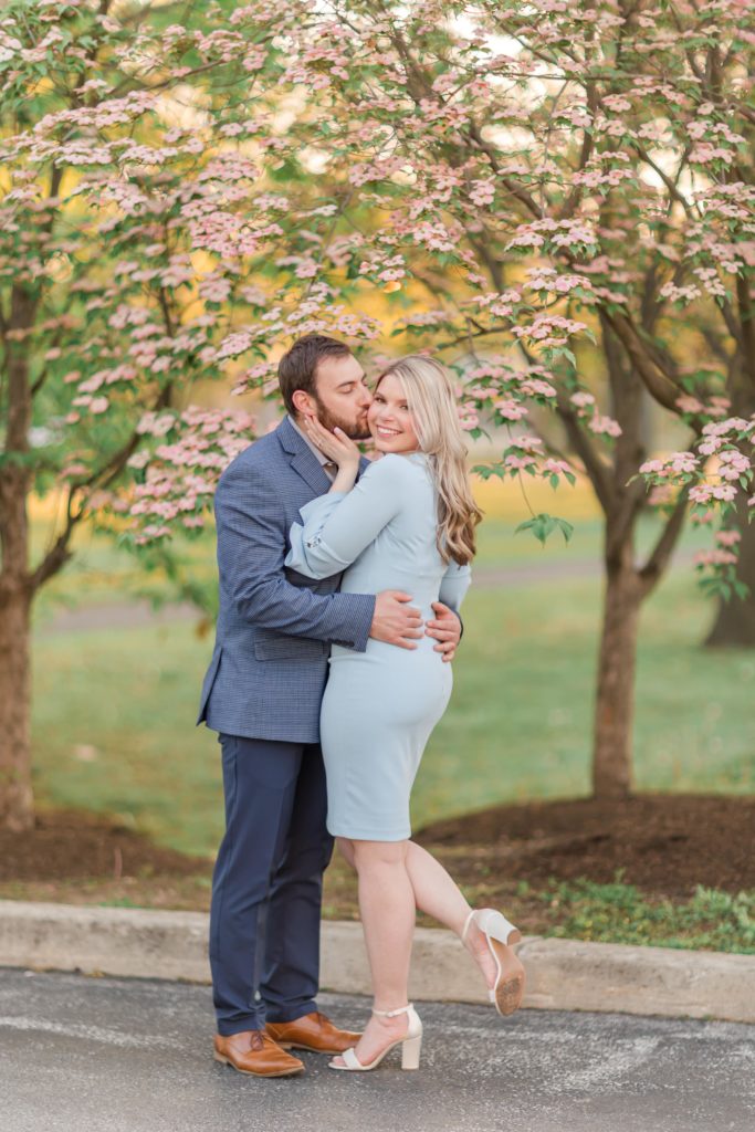Engagement photos in front of pink dogwood tree