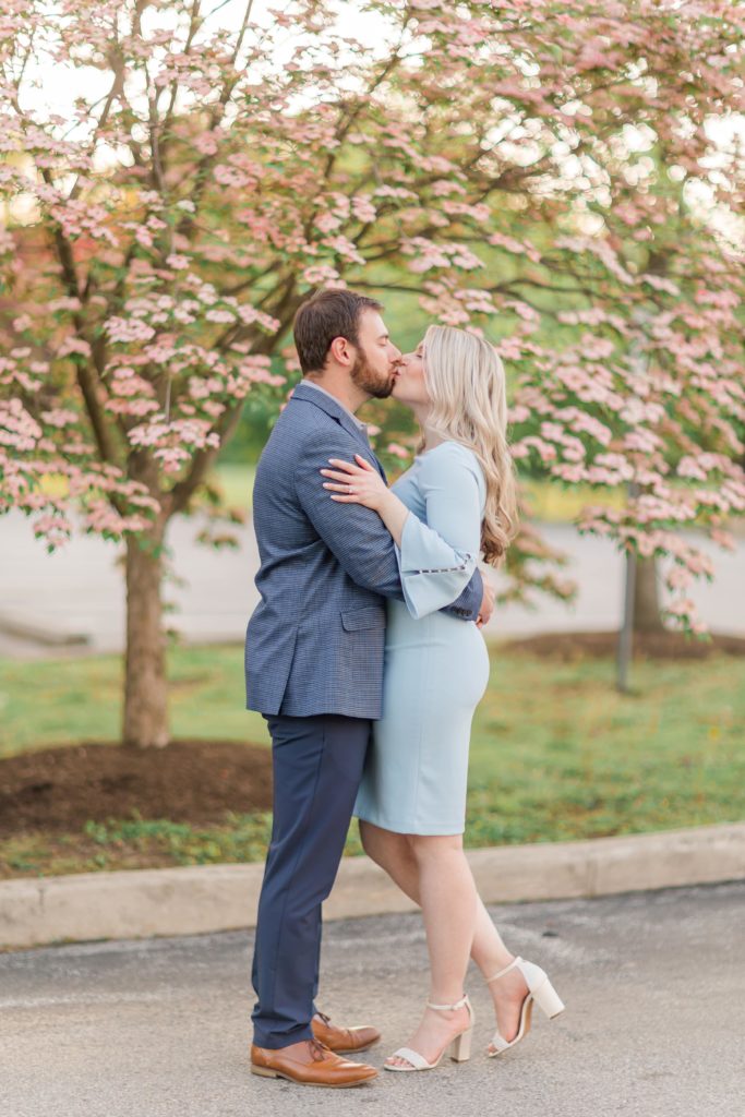 Couple kissing infront of pink dogwood tree