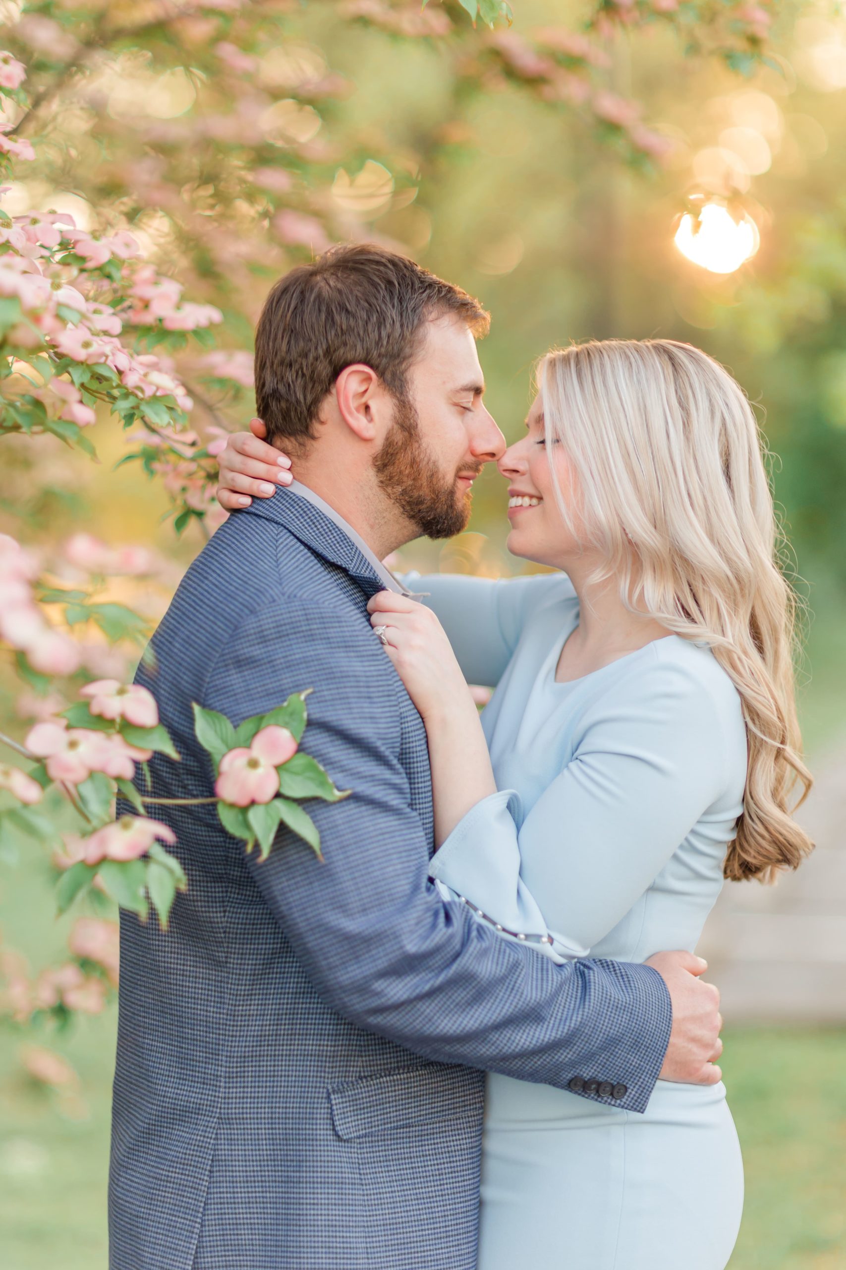 Couple kissing infront of pink dogwood tree