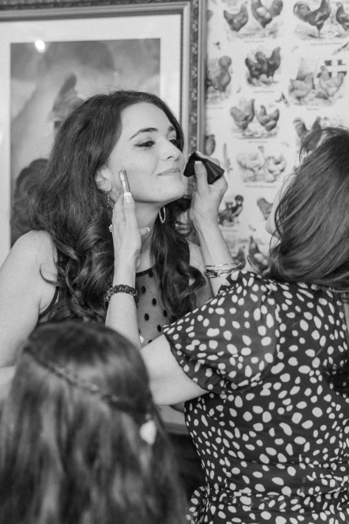 Black and white photo of make up being touched up on girl