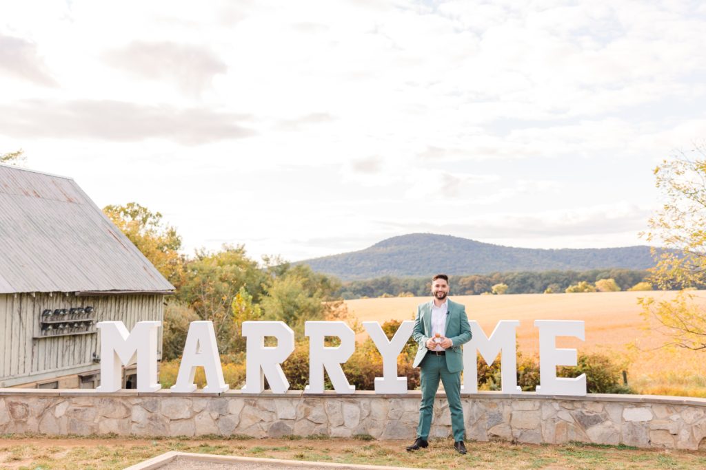 Guy in front of Marry me sign