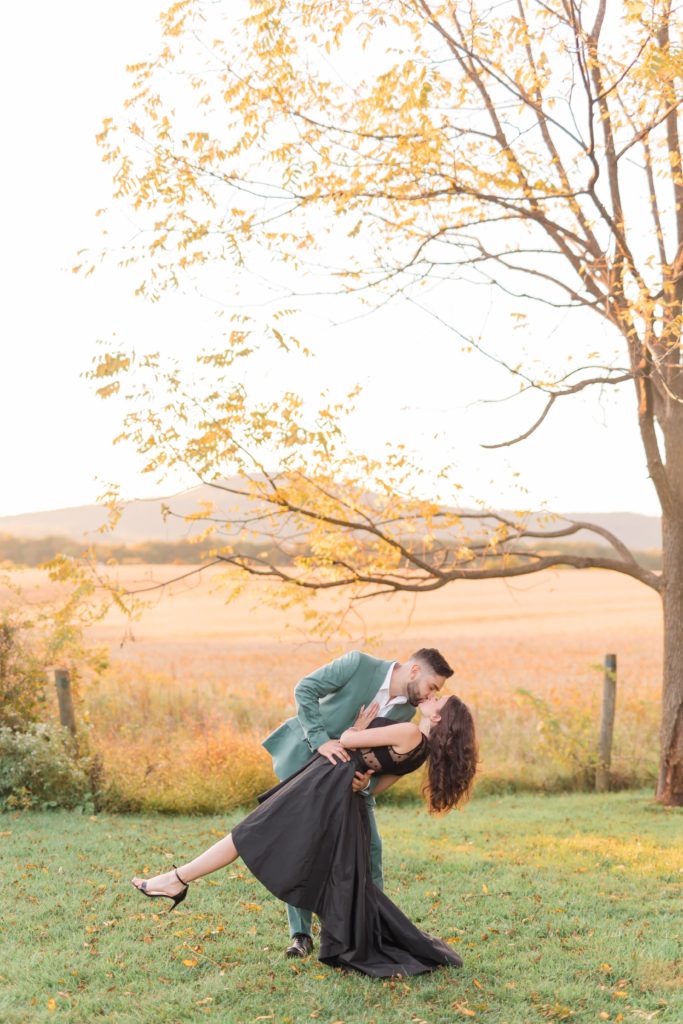 Engagement portrait of a guy in green suit & girl in black dress