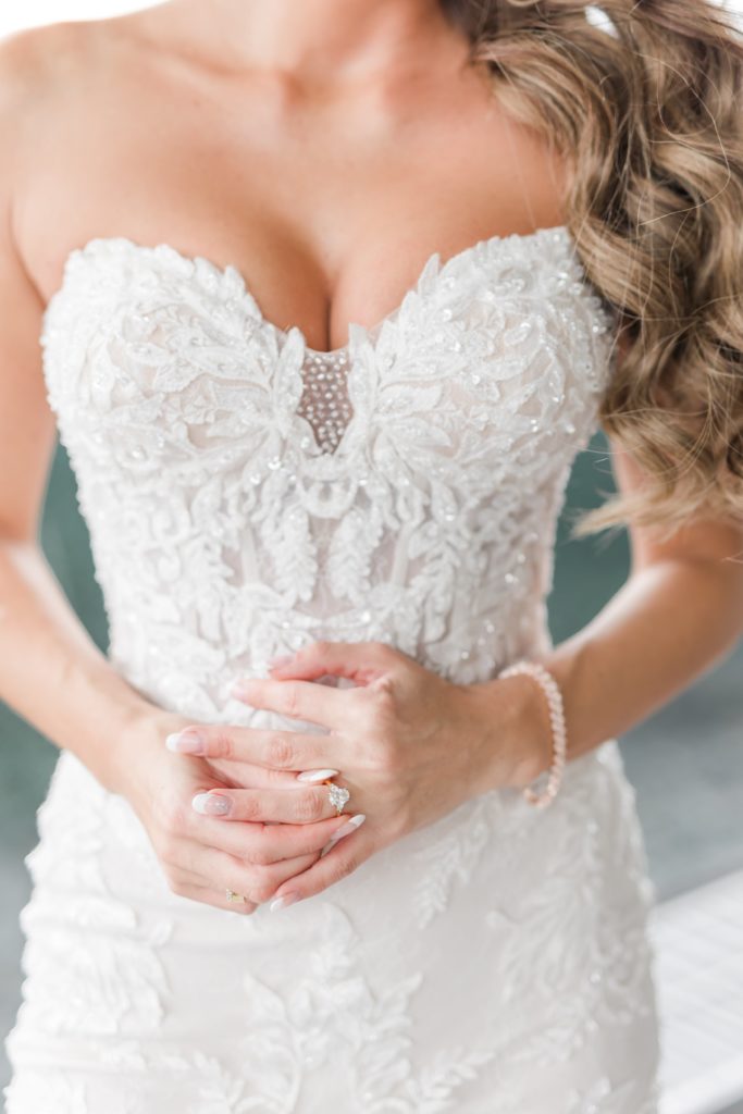 Bride in wedding dress holding wedding ring