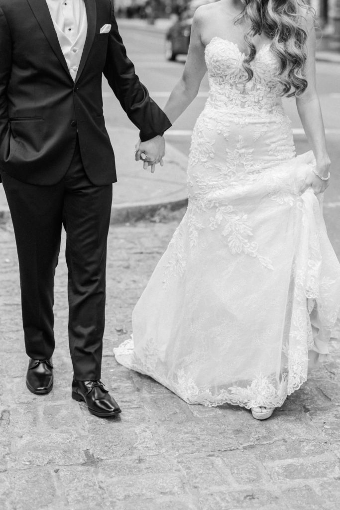 Black and white image of bride and groom holding hands