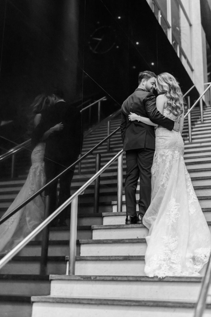 Black and white portraits of bride and groom on mirror stairs