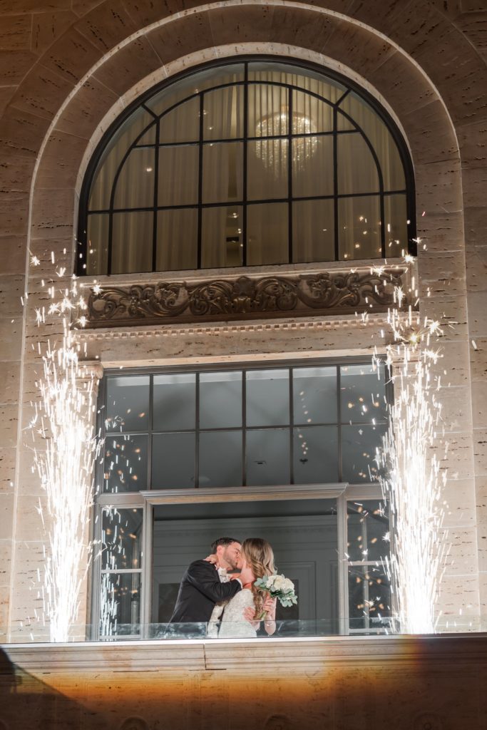 Bride and groom kissing at sparkler grand entrance