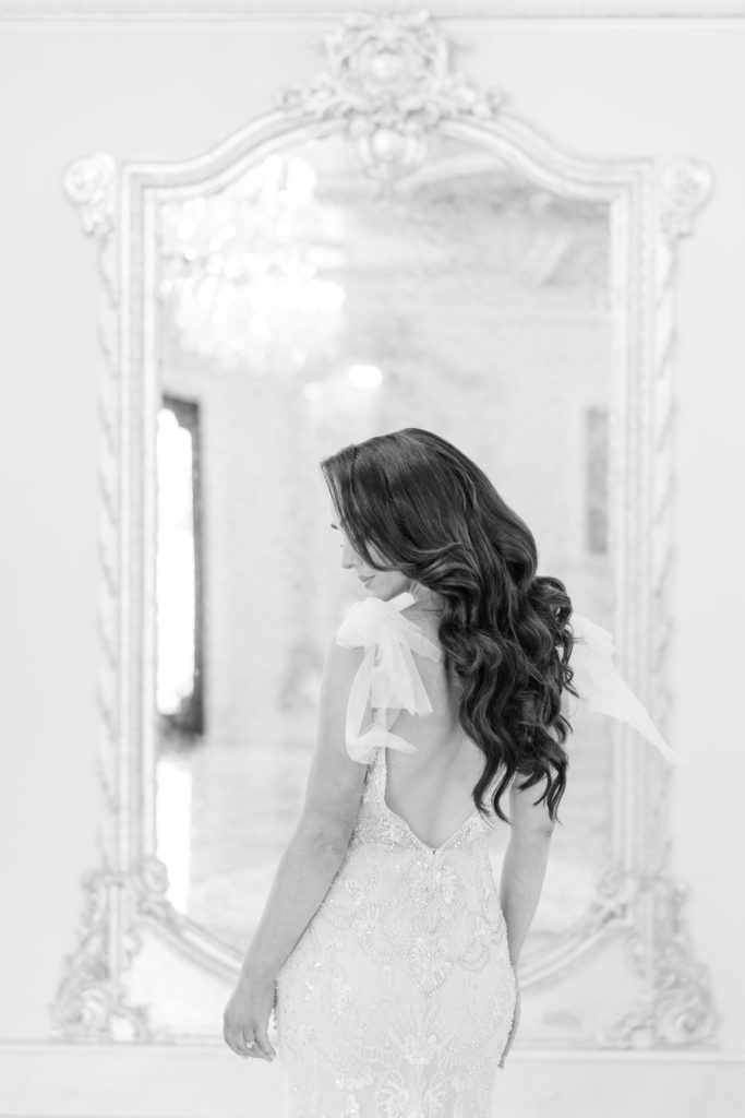 Black and white photo of bride in front of mirror