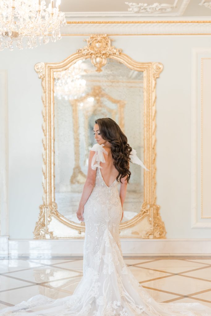 Bride in front of gold mirror in wedding dress