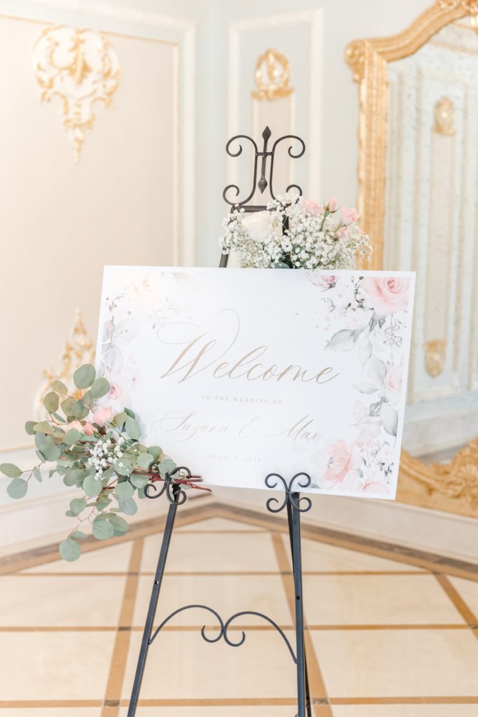 Welcome sign with pink flowers on black easel