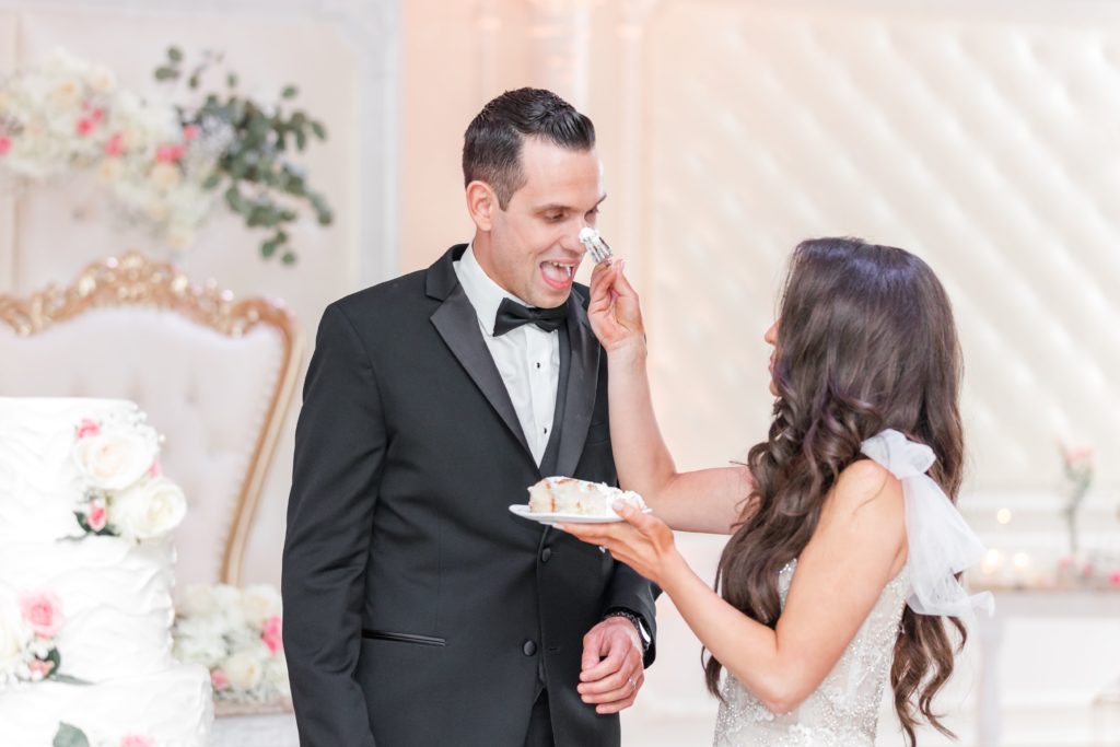 Bride squishing cake on grooms nose