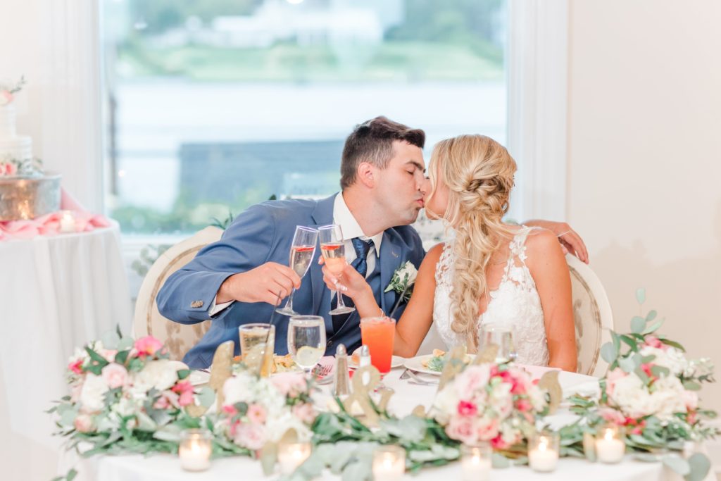 Bride and groom kissing at sweetheart table
