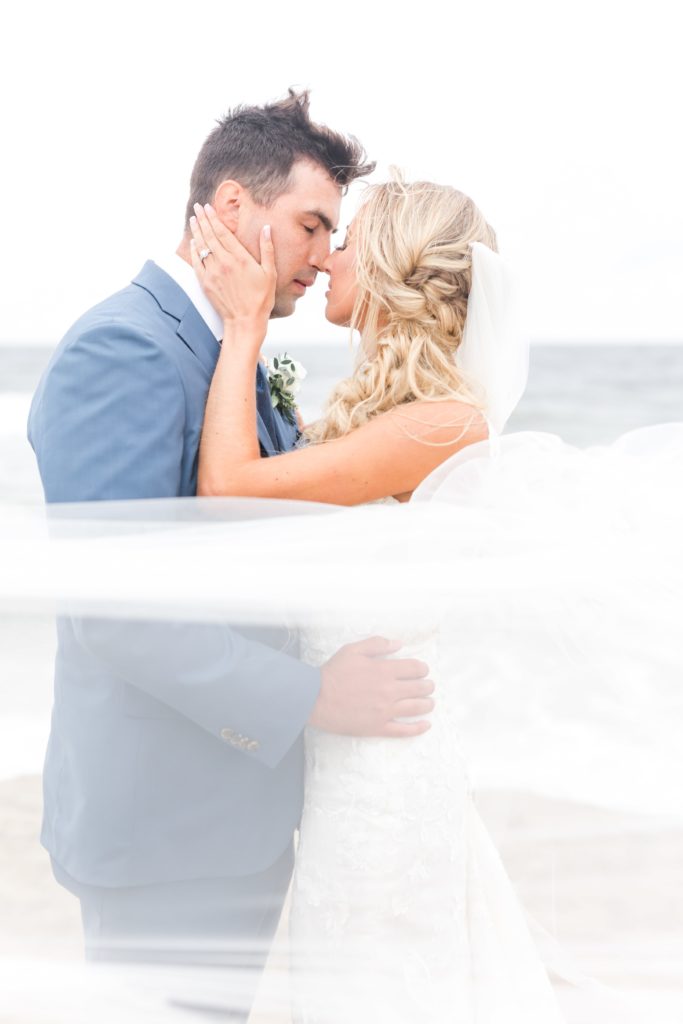 Beach wedding photos of bride and groom kissing