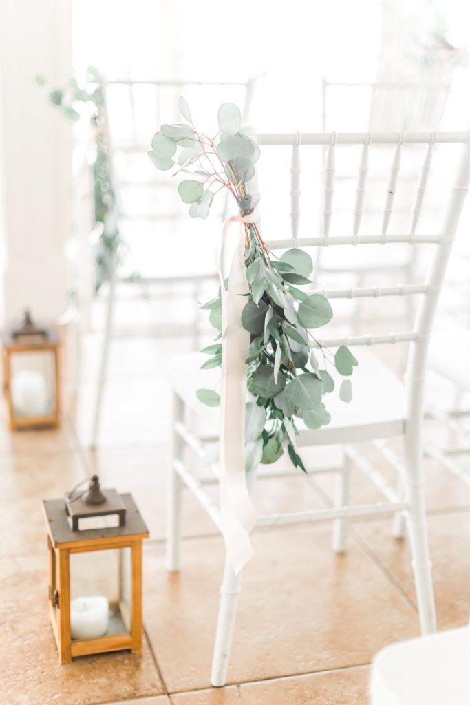 Wood wedding chair with greenery and lantern