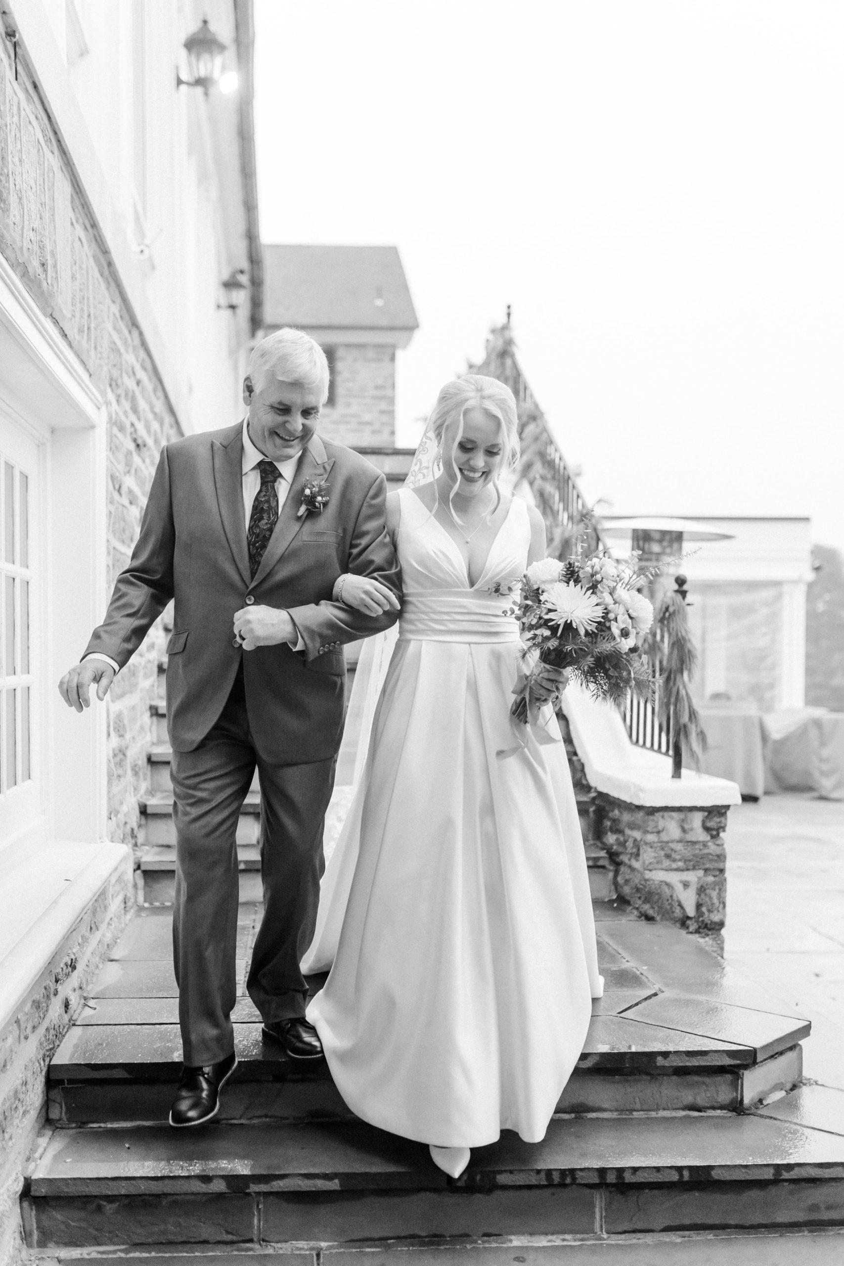 Black and white photo of bride and father walking in ceremony