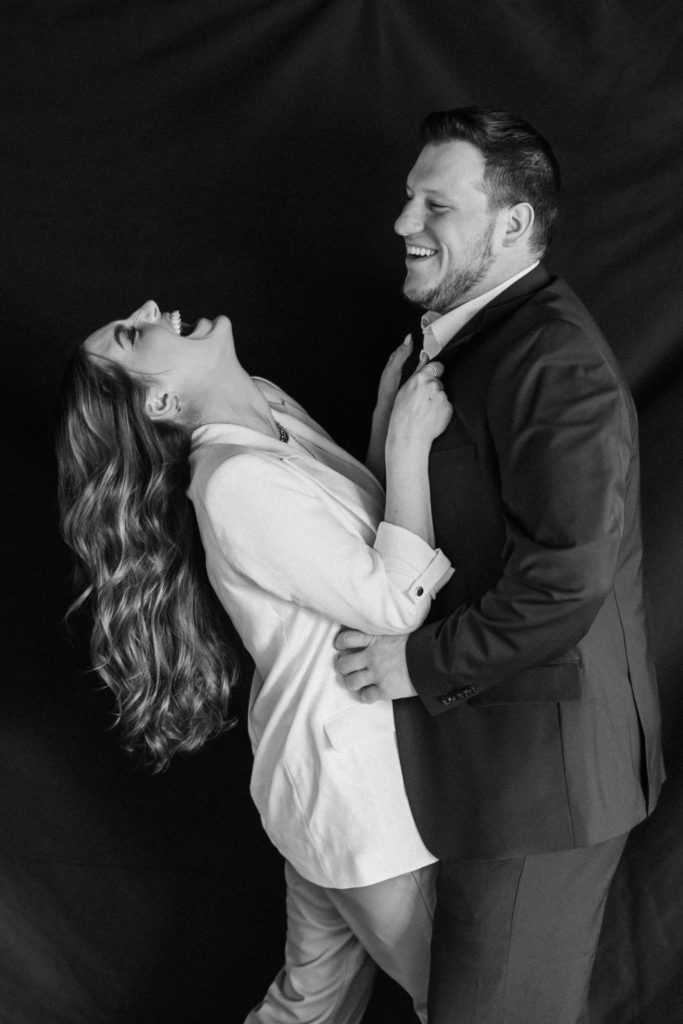 Black and white portrait of engaged couple laughing