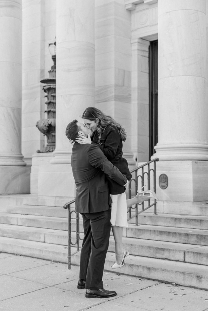 Black and white portrait of guy kissing girl outside Delware County courthouse