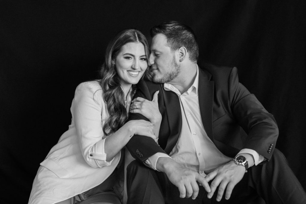 Black and white portait of engaged couple sitting