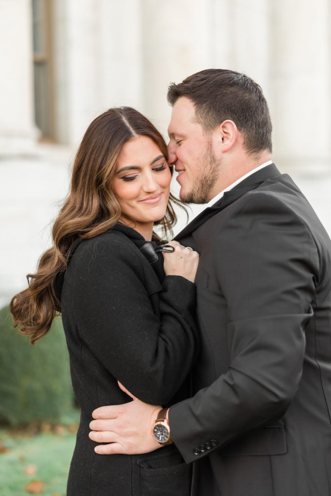Couple in black jackets snuggling during engagement photos