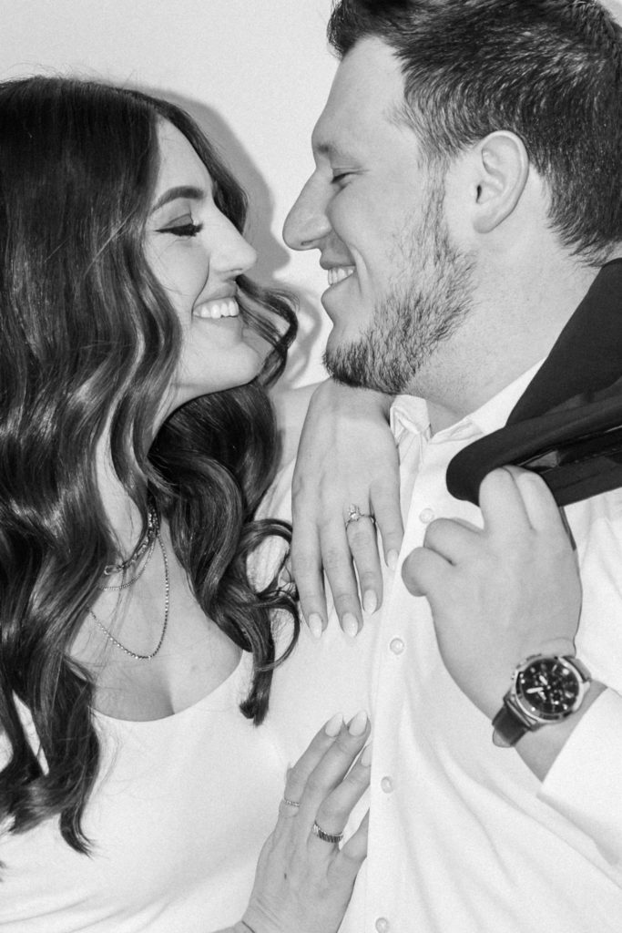 Black and white photo of engaged couple smiling