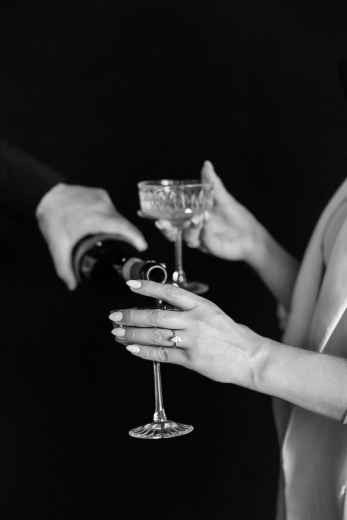 Hands pouring champagne into crystal champagne glasses