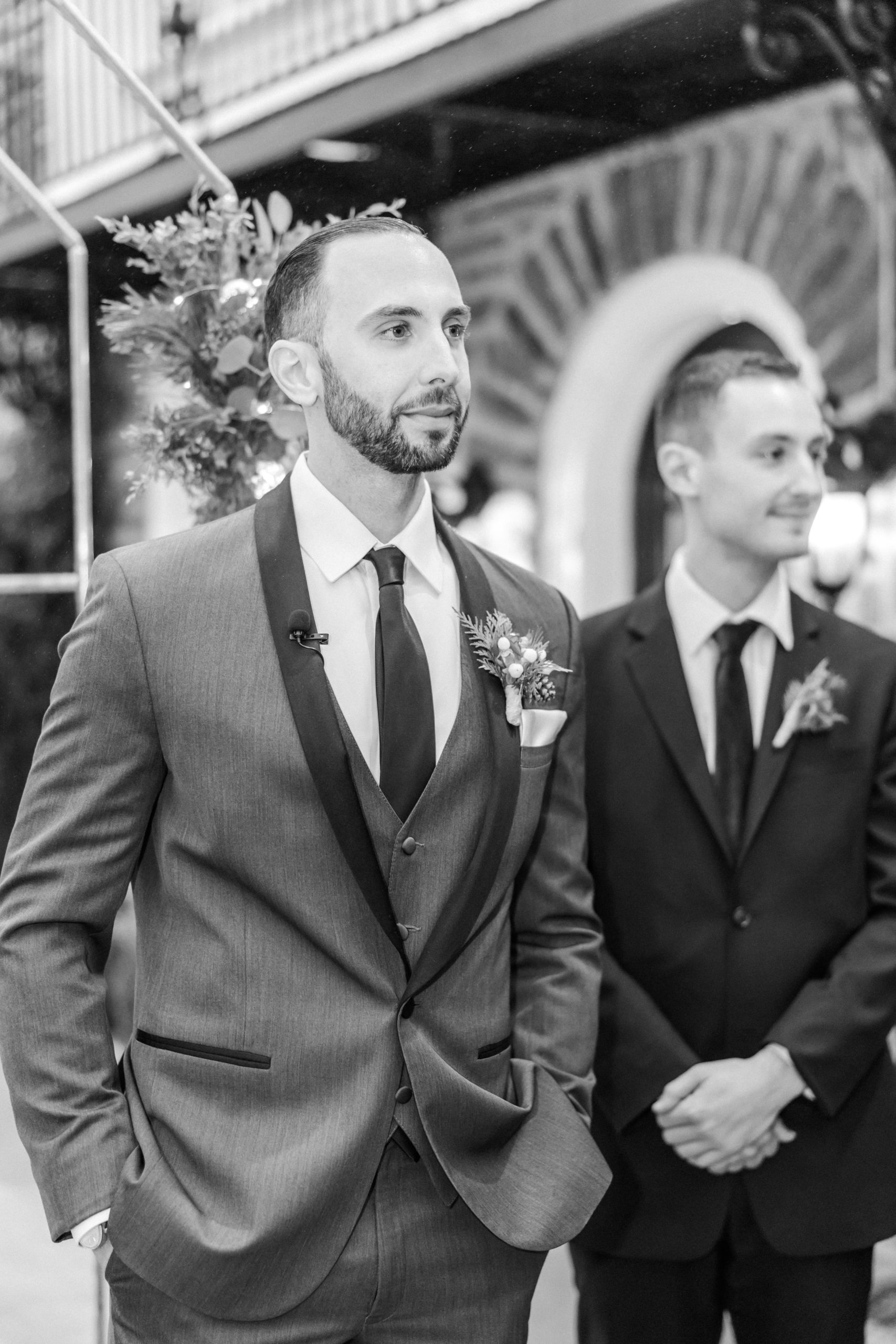 Black and white image of groom at ceremony