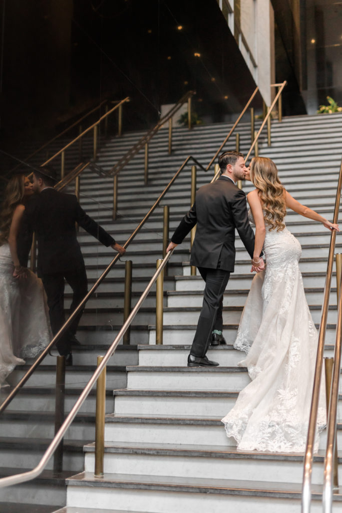 Bride and groom kissing on mirror stairs
