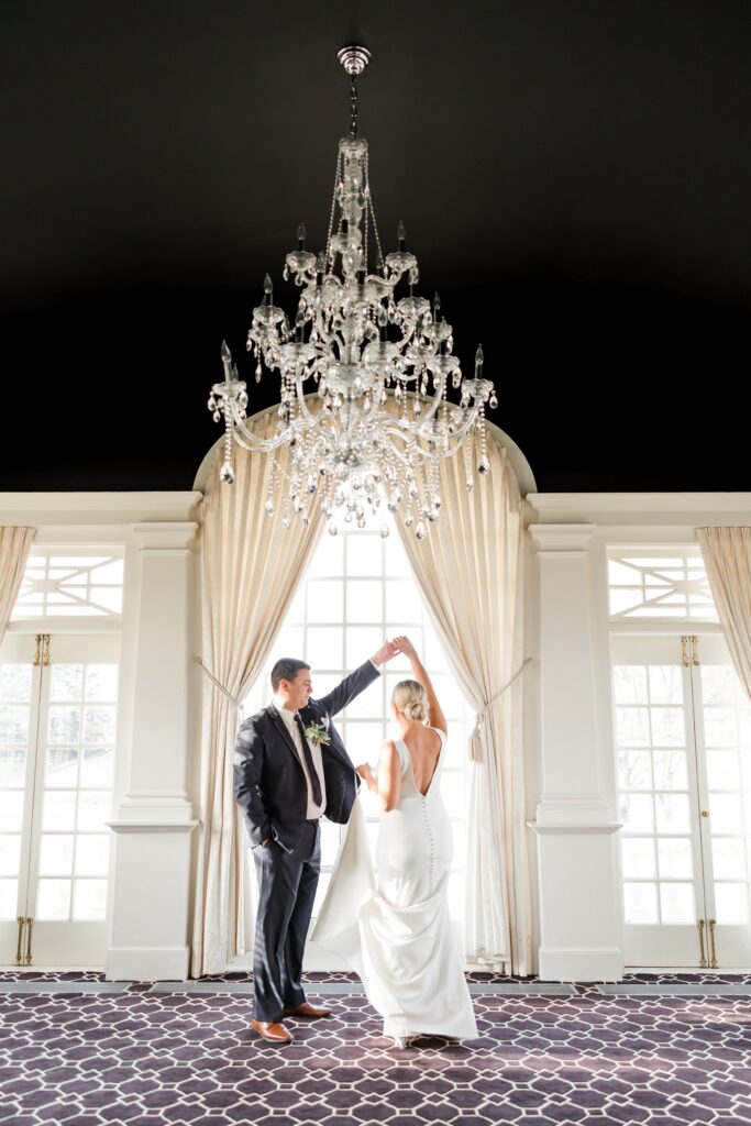 Bride and groom dancing under chandelier