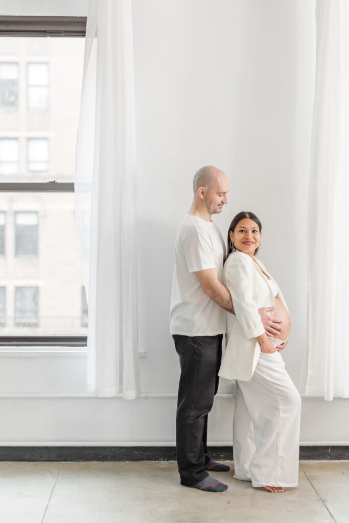 pregnant lady dressed in white blazer & pants with man in white shirt