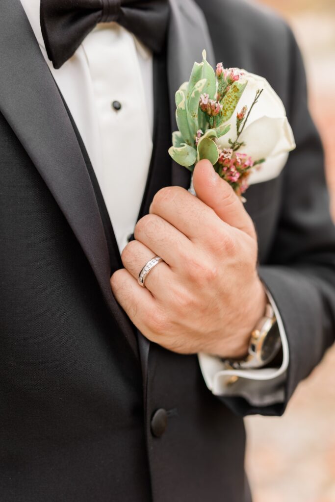 Groom in black tuxedo with white boutonniere